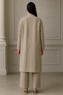 Back view of a model wearing an elegant beige coat and wide-leg trousers