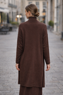 Back view of model wearing brown 3 Piece Sweater Skirt Set with A-line silhouette on a cobblestone street, adding sophistication to any look.