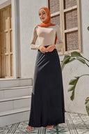Woman in modest black satin maxi skirt attire